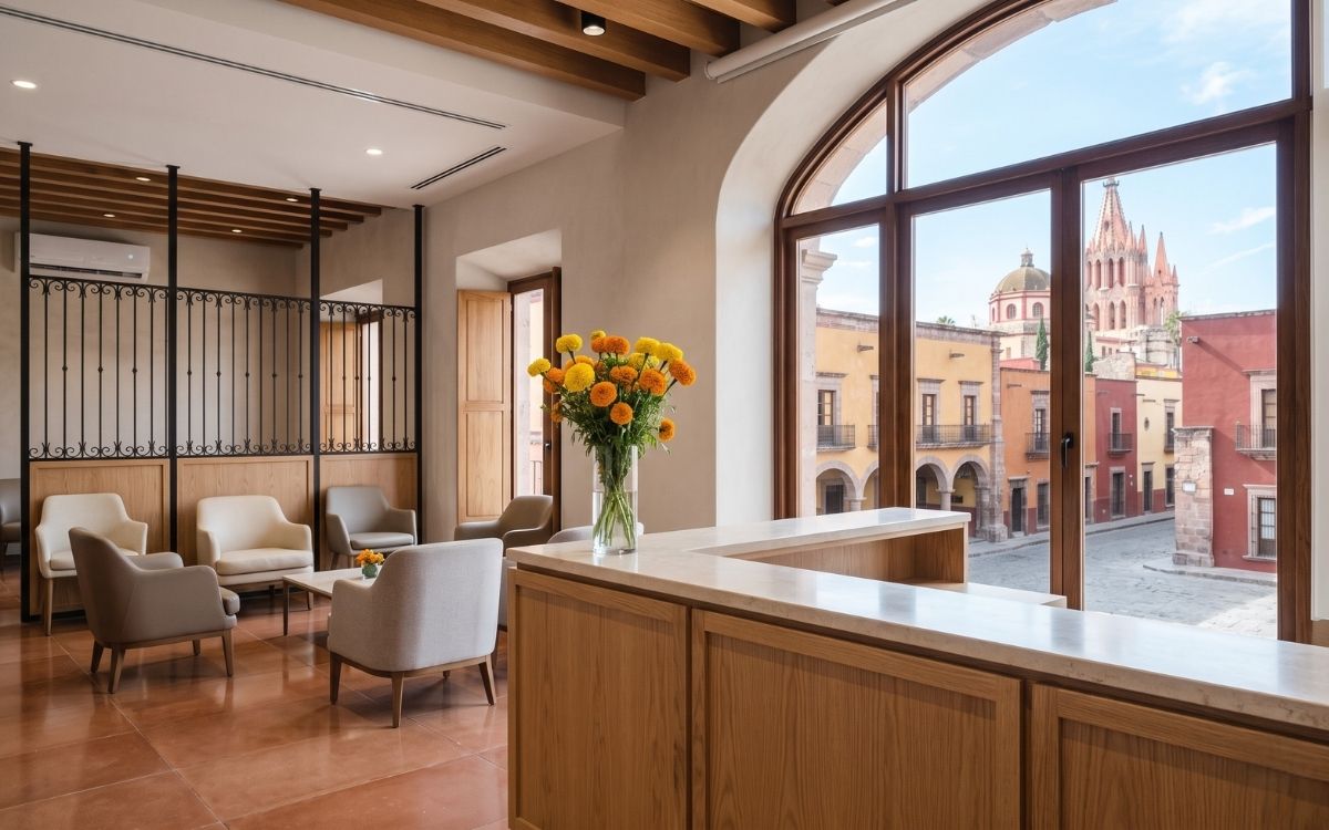 Clean modern Mexican hospital reception area with warm colonial design touches and natural light from a large window